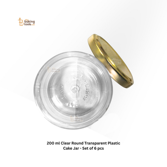 Clear round transparent plastic cake jar with gold lid on a white background
