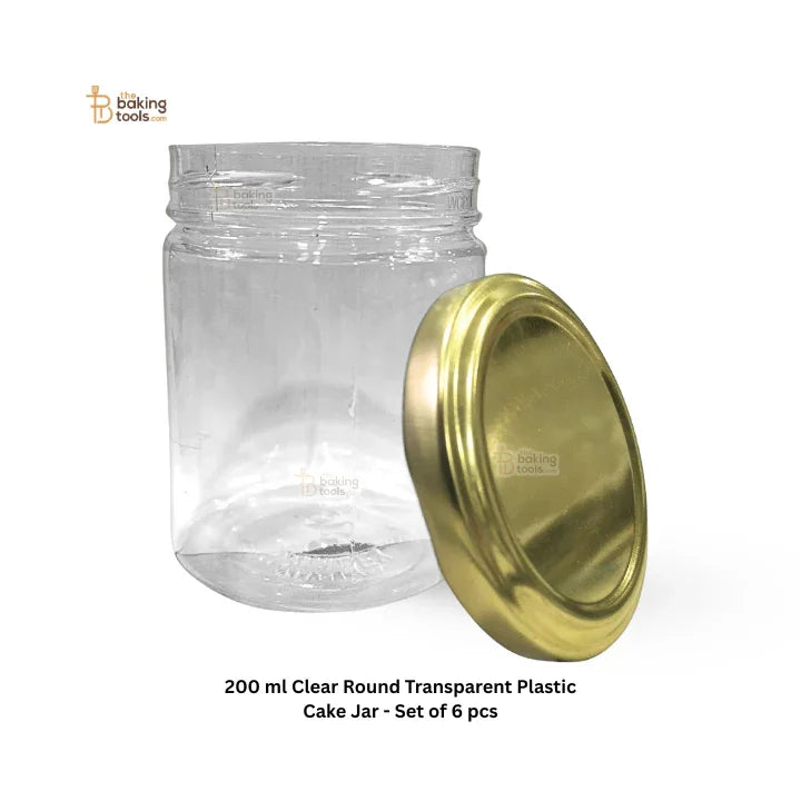 Clear round transparent plastic cake jar with a gold lid on a white background