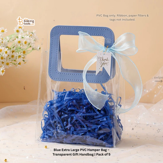Blue PVC hamper bag with blue shredded paper and a white ribbon on a beige background.