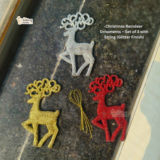 Set of three Christmas reindeer ornaments in gold, silver, and red on a dark surface.