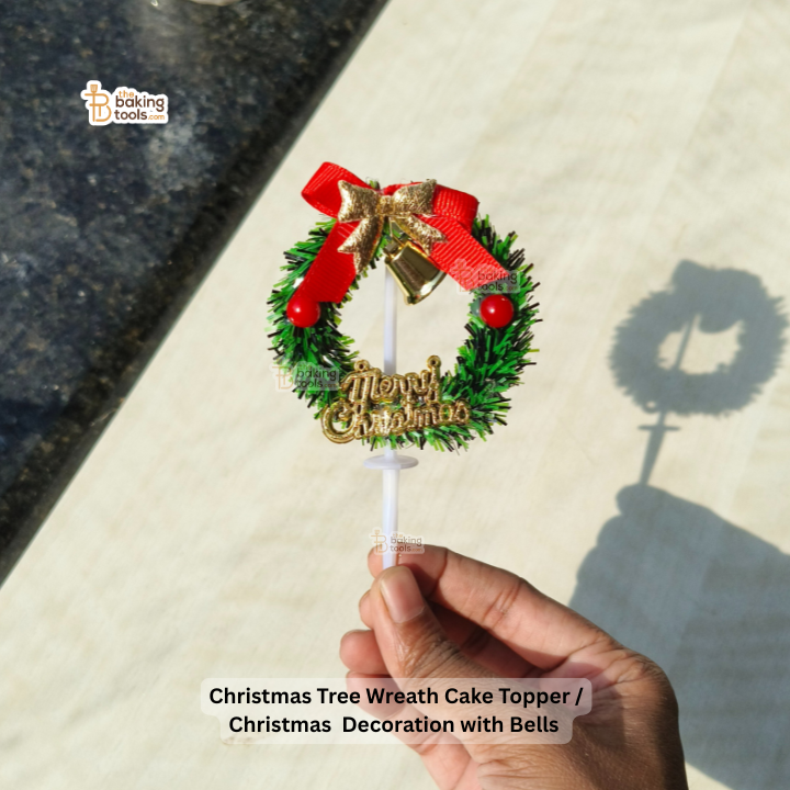 Christmas Tree Wreath Cake Topper held by a hand on a light surface with 'Baking Tools' branding.