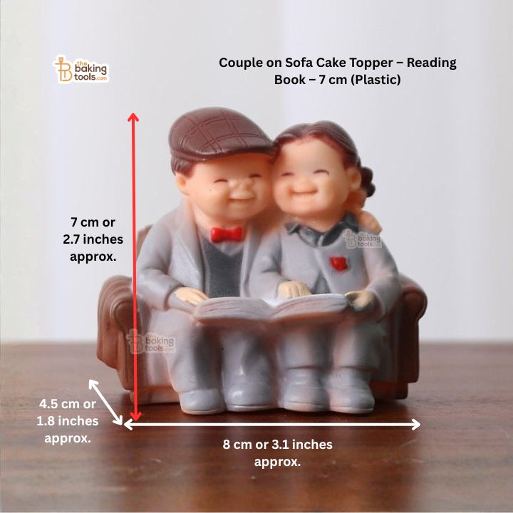 Couple on sofa cake topper reading a book with dimensions indicated.