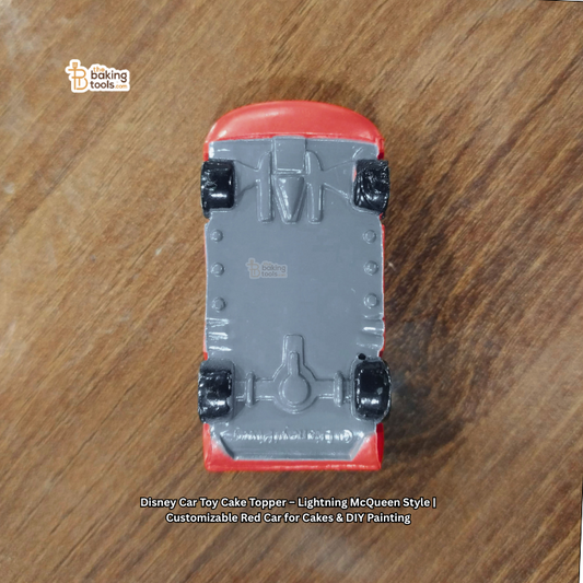 Toy car cake topper on a wooden surface with 'baking tools' branding.