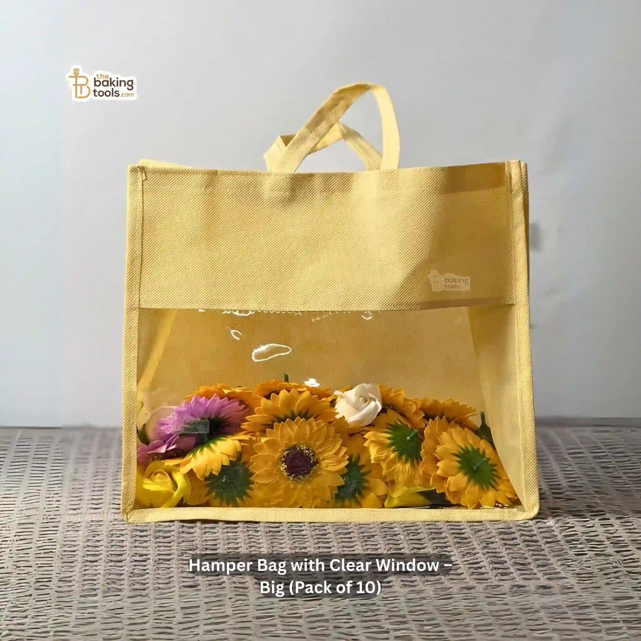 Hamper Bag with Clear Window containing flowers on a textured surface. Big in size, 12 by 14 by 5 inches, and it's a pack of 10 pcs