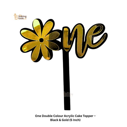 Black and gold acrylic cake topper with 'one' and flower design on a white background