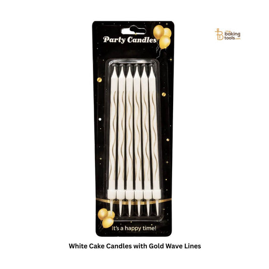 white cake candles with gold wave line pattern