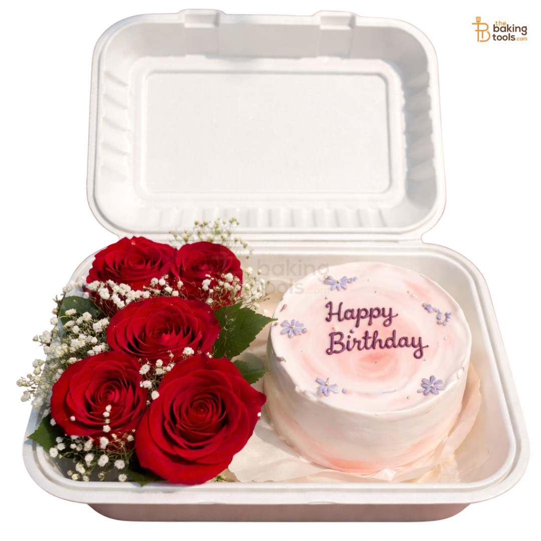 White takeout container with red roses and a small birthday cake inside.