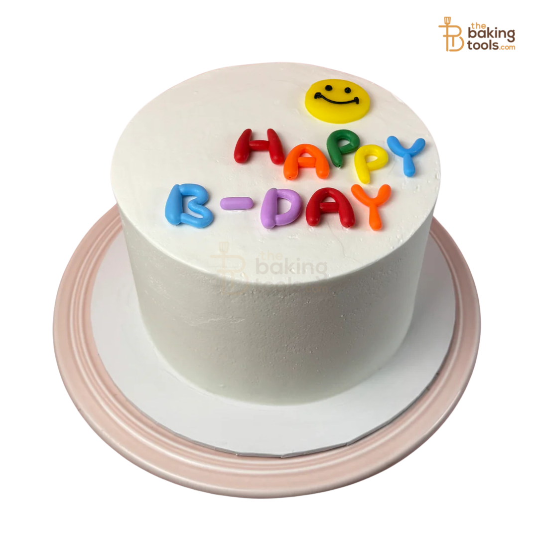 White birthday cake with colorful 'Happy Birthday' letters and a smiley face on a white background.